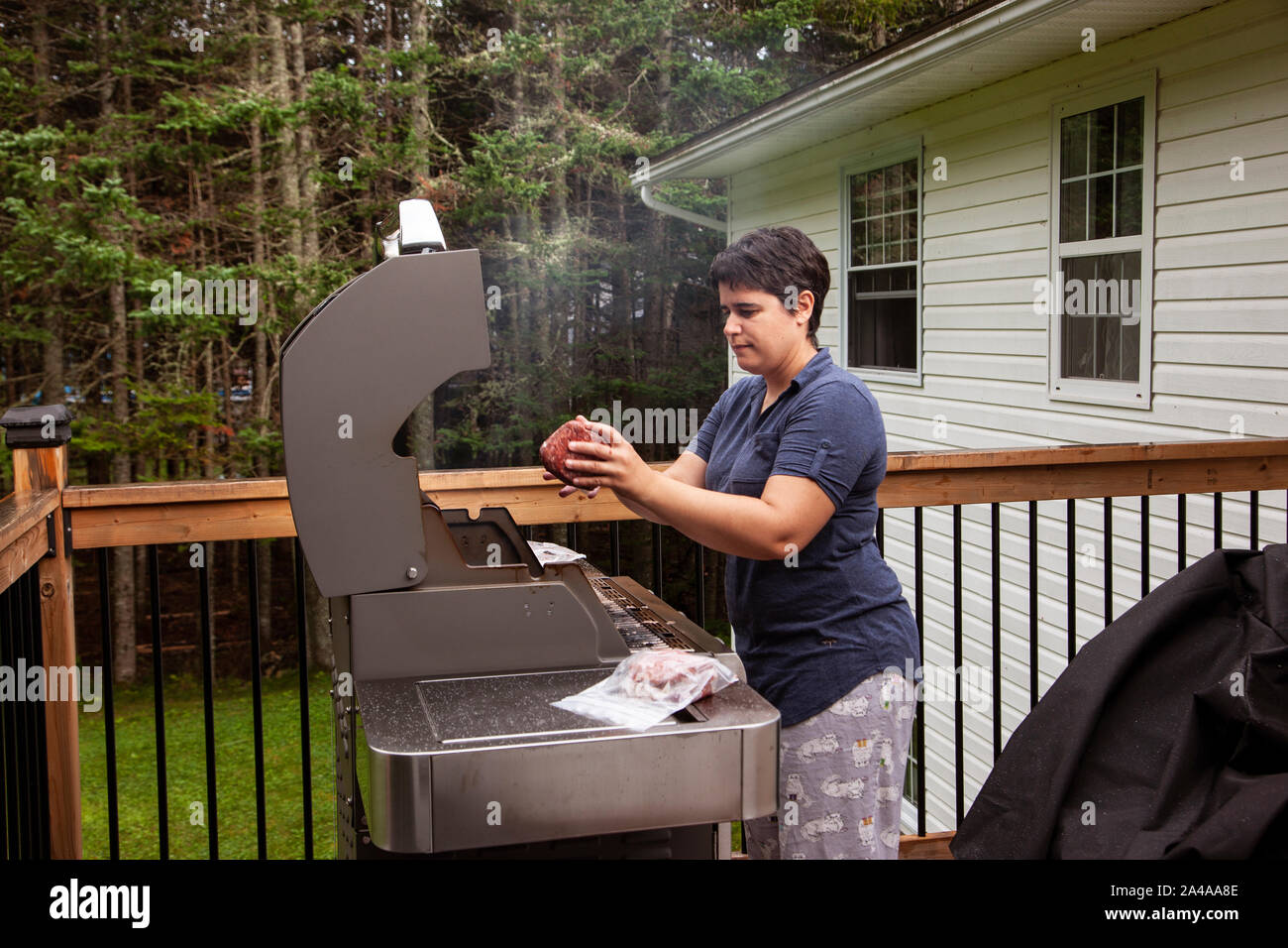 person bbq'ing their hamburger meat on the deck Stock Photo