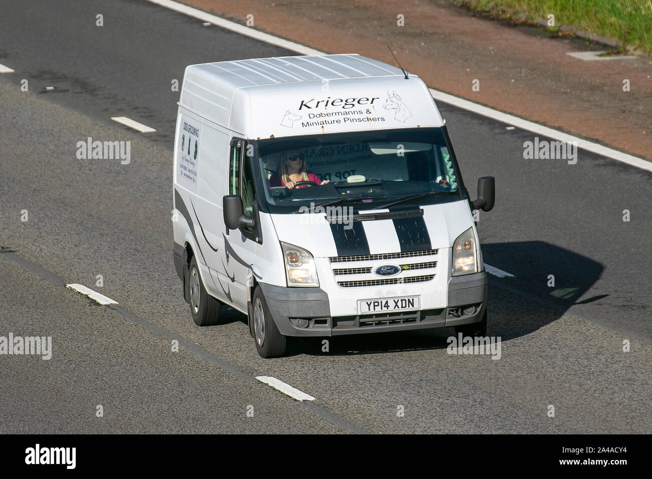 2014 white Ford Transit 100 T260 FWD; UK Vehicular traffic, transport, modern, south-bound on the 3 lane M6 motorway highway. Stock Photo