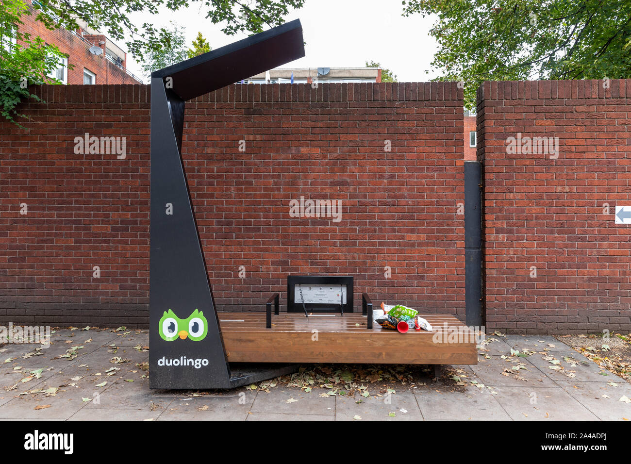 A Duolingo smart bench and a Strawberry Energy solar powered free mobile charging point on a city street in London. Stock Photo