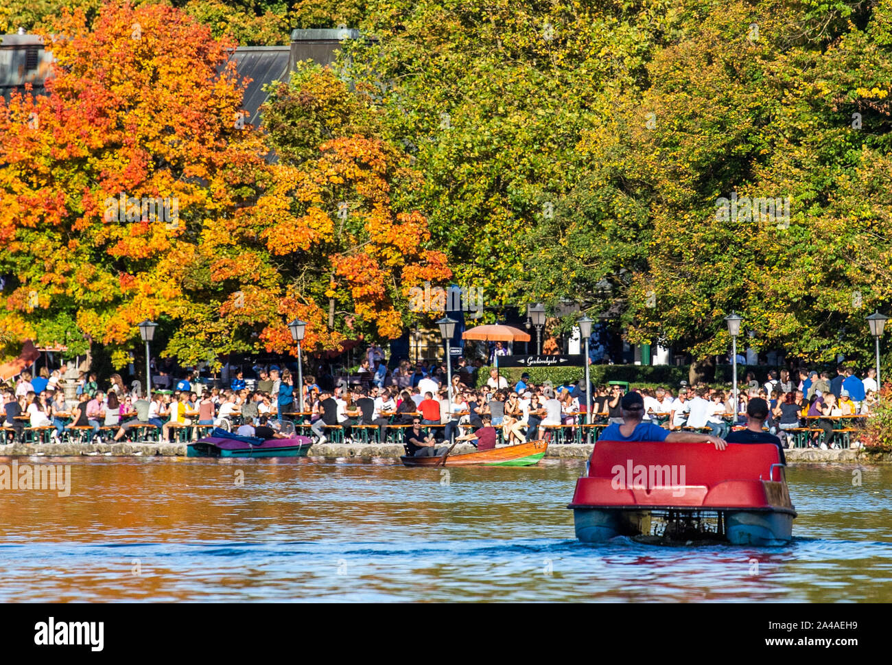 Munich, Germany. 13th Oct, 2019. Persons in pedal boats ride in front of the beer garden from the Seehaus in the English Garden on the Kleinhesseloher See. Credit: Lino Mirgeler/dpa/Alamy Live News Stock Photo