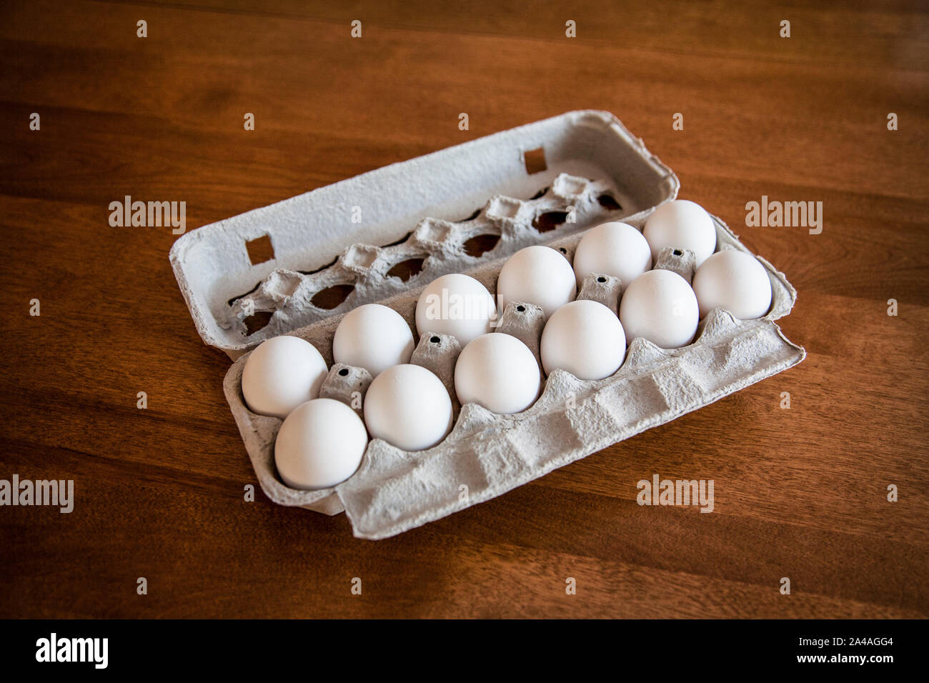 One dozen white eggs in an egg carton on a wooden table background, New Jersey, USA, US, farm eggs Stock Photo