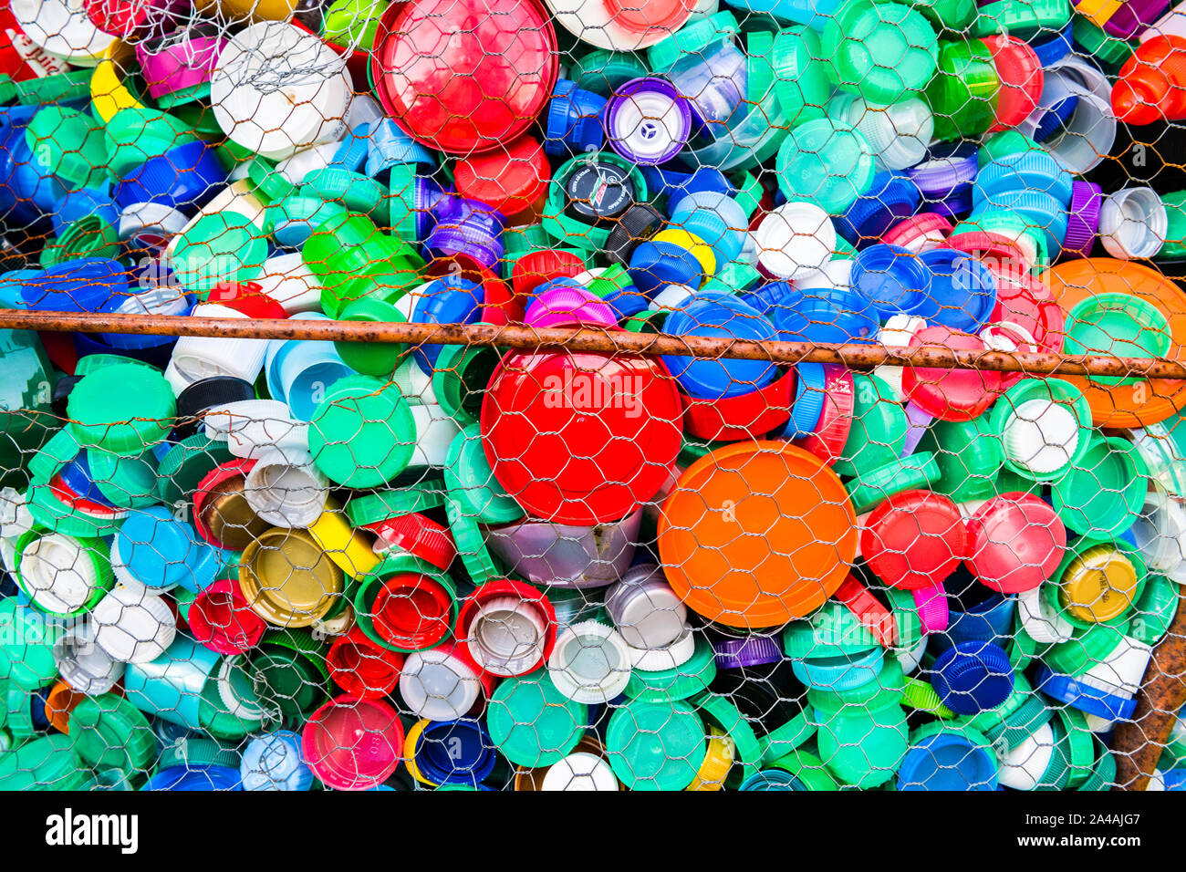 Large colection of coloured plastic bottle tops forming a wired sculpture. Stock Photo