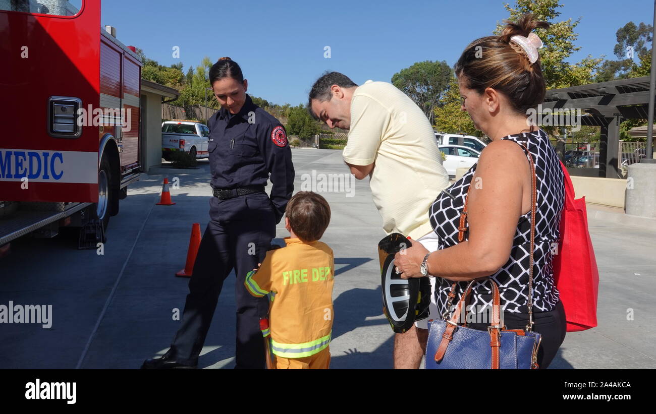 A family gets to meet with firefighters at fire station open house. Stock Photo