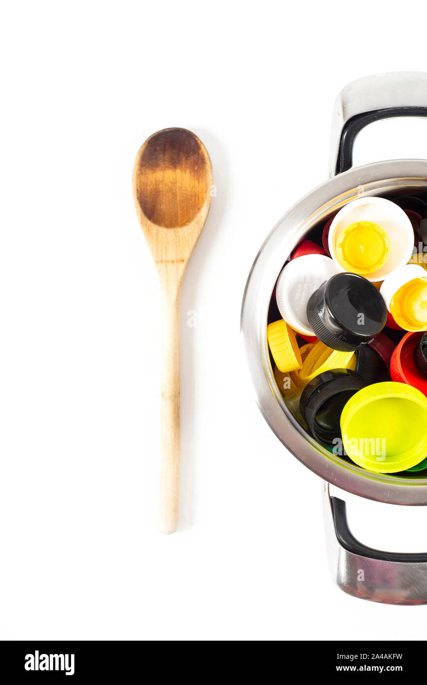 A saucepan filled with plastic lids and a wooden spoon Stock Photo
