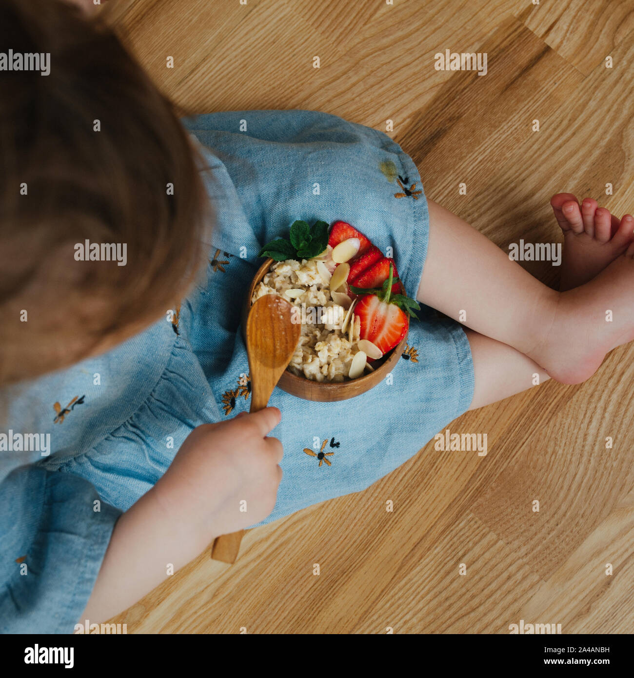 Baby eat porridge with strawberries. Square closeup shot Stock Photo