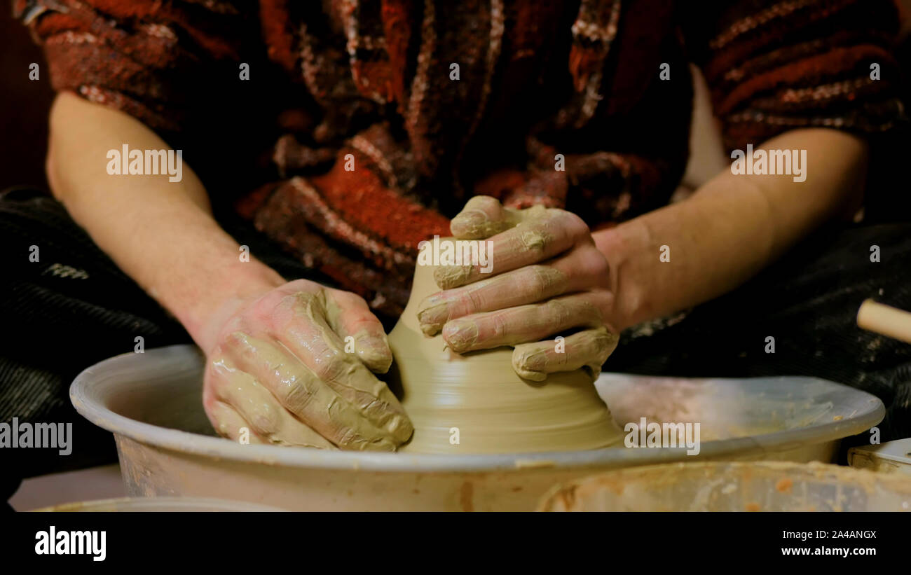 Professional male potter working with clay on potter's wheel Stock