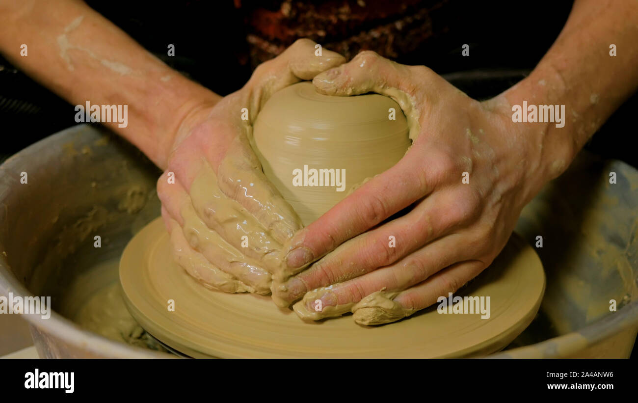 Professional male potter working with clay on potter's wheel Stock