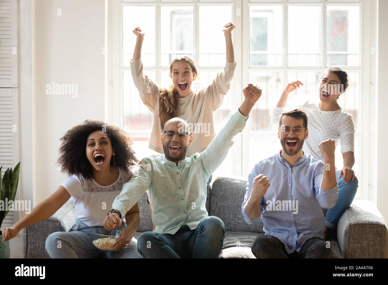 Excited diverse friends celebrating successful football match result Stock Photo