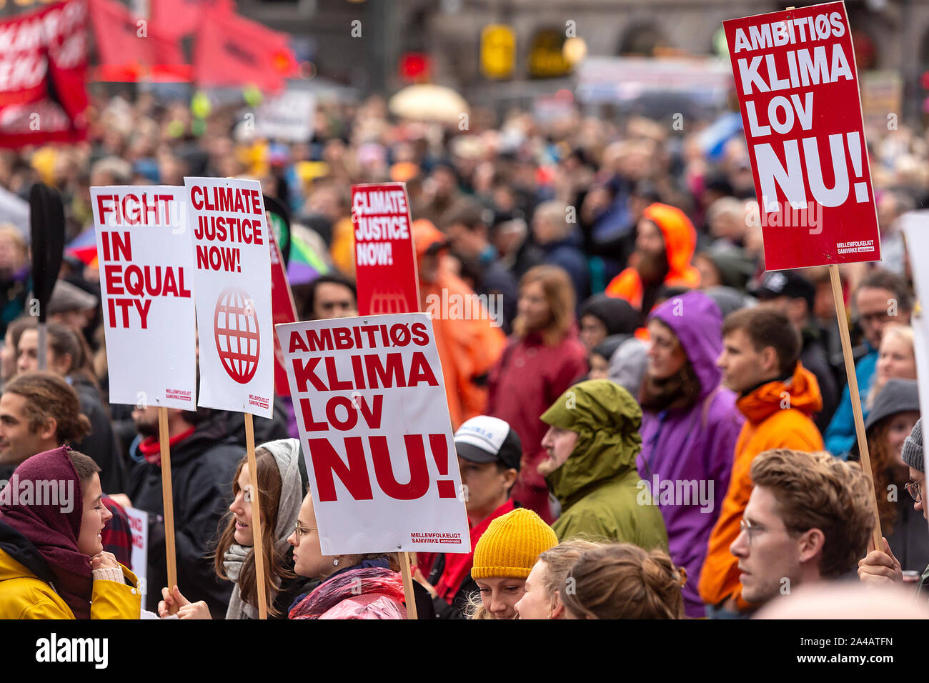 COPENHAGEN, DENMARK – OCTOBER 11, 2019:  Thousands of people gather at a People’s Climate March at Copenhagen City Hall Square and demanded swift and extensive climate action, which marks the conclusion of the C40 World Mayors Summit during this week in Copenhagen.  To the right a sign with the text in English: ‘Ambitious climate law now’. This refers to a popular demand for a statutory framework condition for the Danish Governments climate efforts, which includes obligations to define binding climate goals. Stock Photo