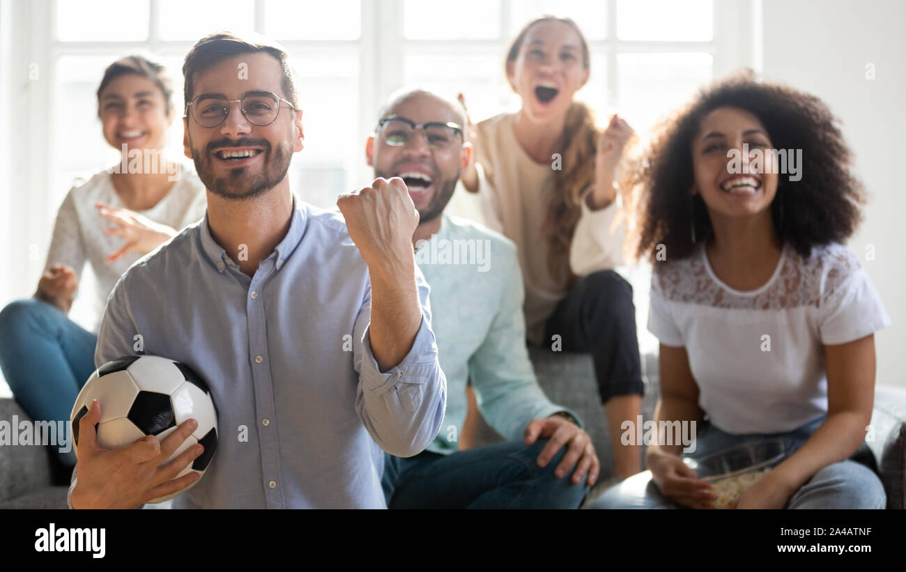 Happy man in glasses watching football match, celebrating goal Stock