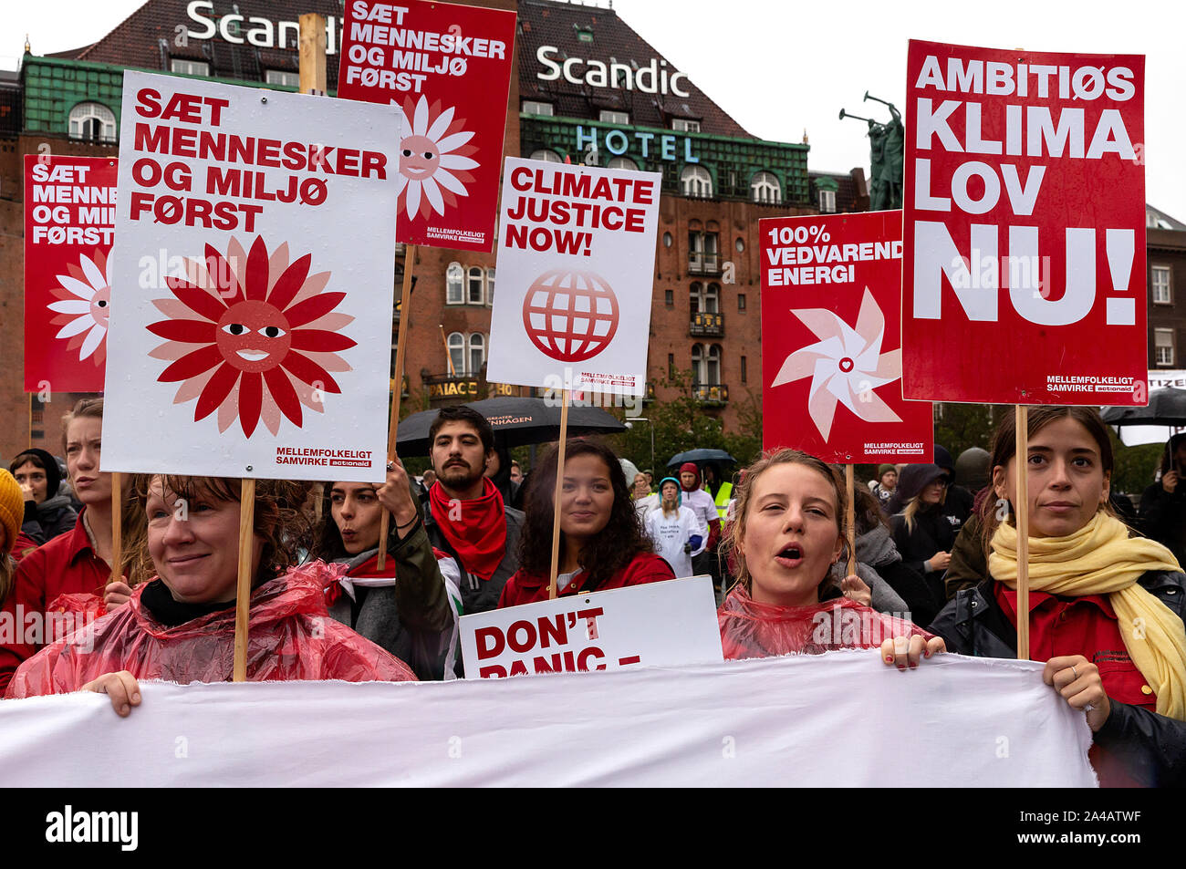 COPENHAGEN, DENMARK – OCTOBER 11, 2019:  Thousands of people gather at a People’s Climate March at Copenhagen City Hall Square and demanded swift and extensive climate action, which marks the conclusion of the C40 World Mayors Summit during this week in Copenhagen.  To the right a sign with the text in English: ‘Ambitious climate law now’. This refers to a popular demand for a statutory framework condition for the Danish Governments climate efforts, which includes obligations to define binding climate goals. Stock Photo