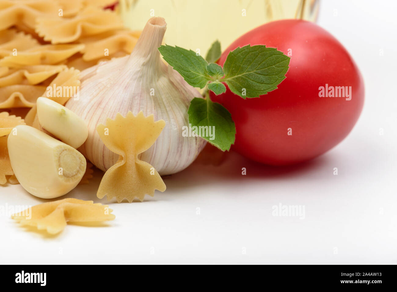 Pasta cooking ingredients. Italian farfalle with vegetables, oil and herbs. Stock Photo