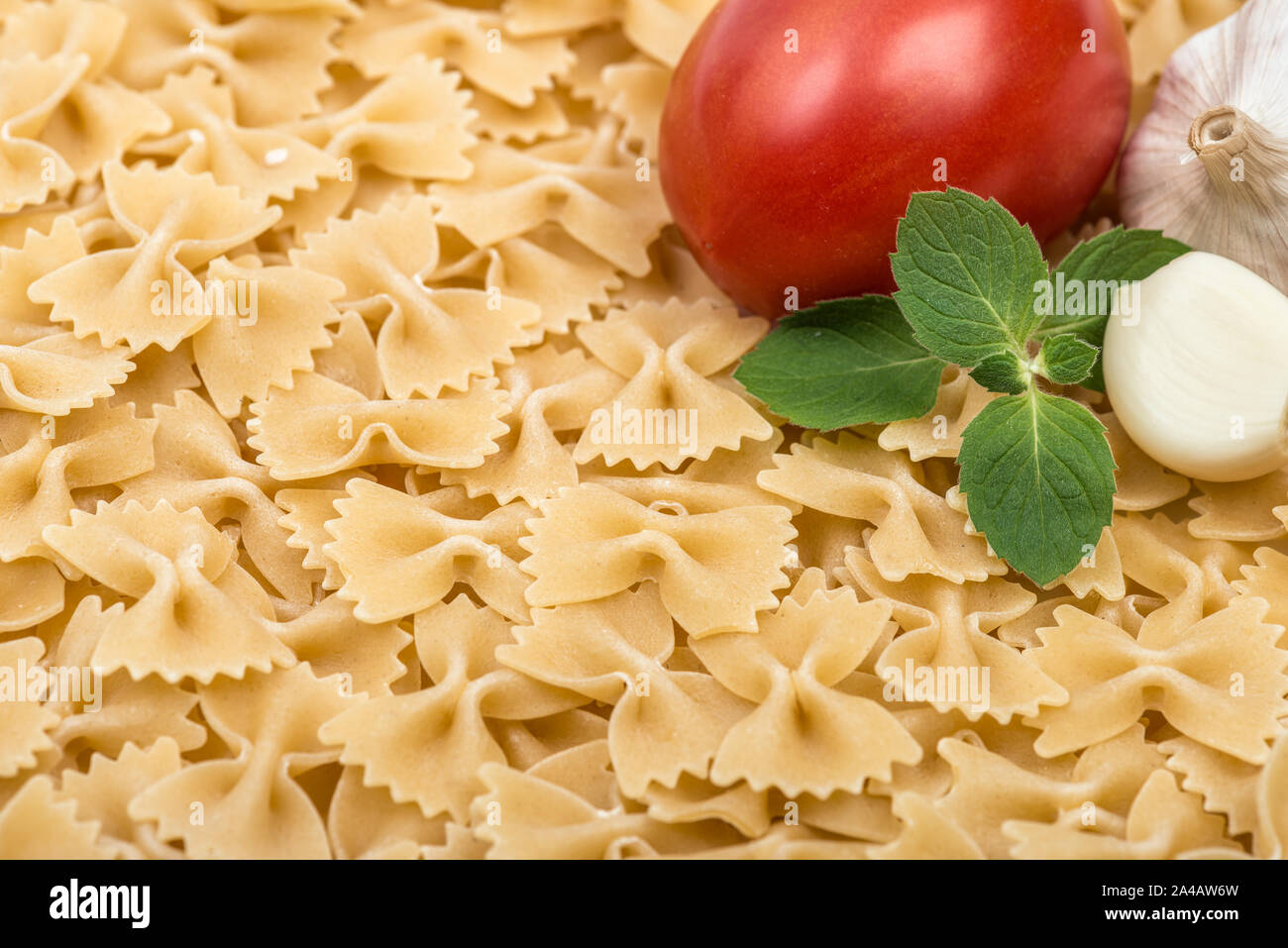 Pasta cooking ingredients. Italian farfalle with vegetables and herbs. Food background Stock Photo