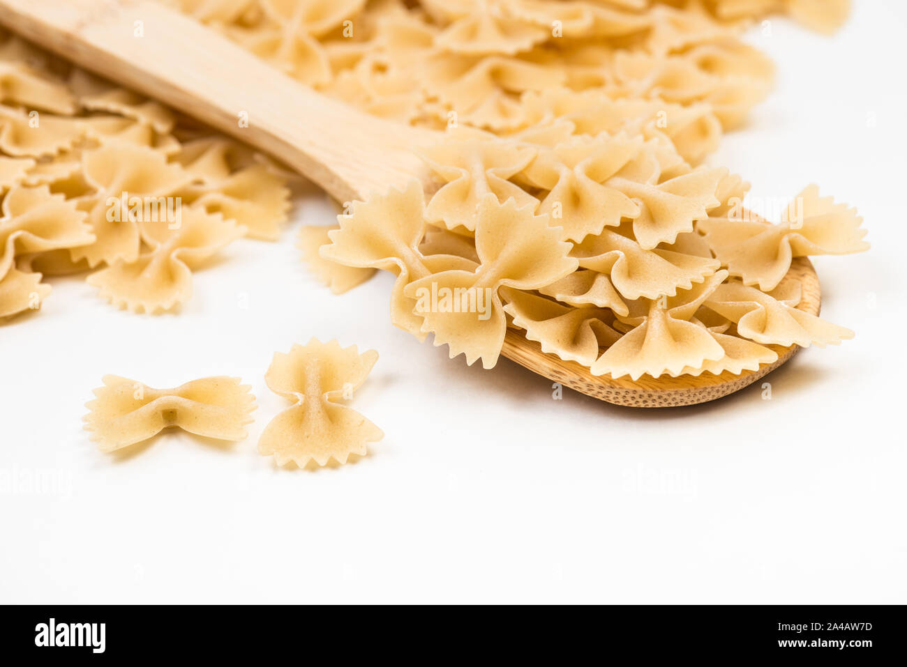 Pasta farfalle on white background. Raw uncooked tie bow shaped italian macaroni product Stock Photo