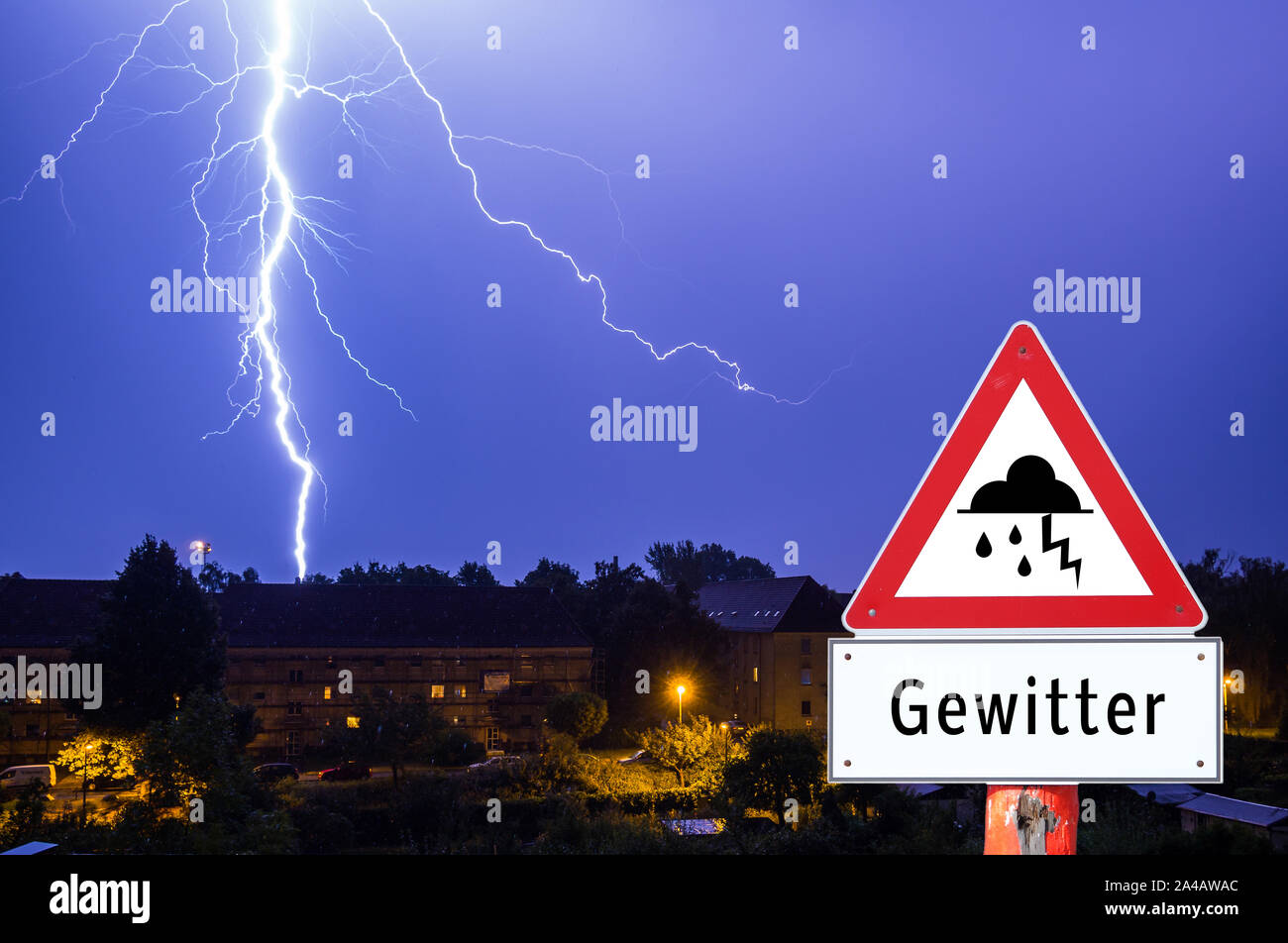 lightning storm in the evening with city lights german warning sign Stock Photo