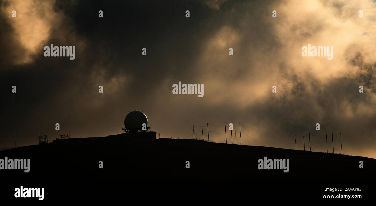The radar tracking golf ball and masts at Saxa Vord in stormy sunlight