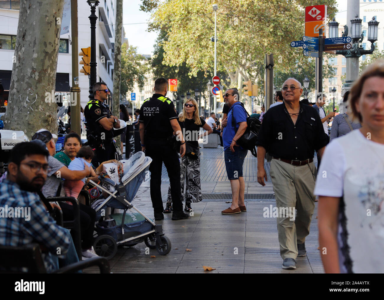 Barcelona, Spain. 12th Oct, 2019. Tourists speaks with catalan police Mossos de Esquadra at Ramblas street in Barcelona. Credit: Clara Margais/dpa/Alamy Live News Stock Photo