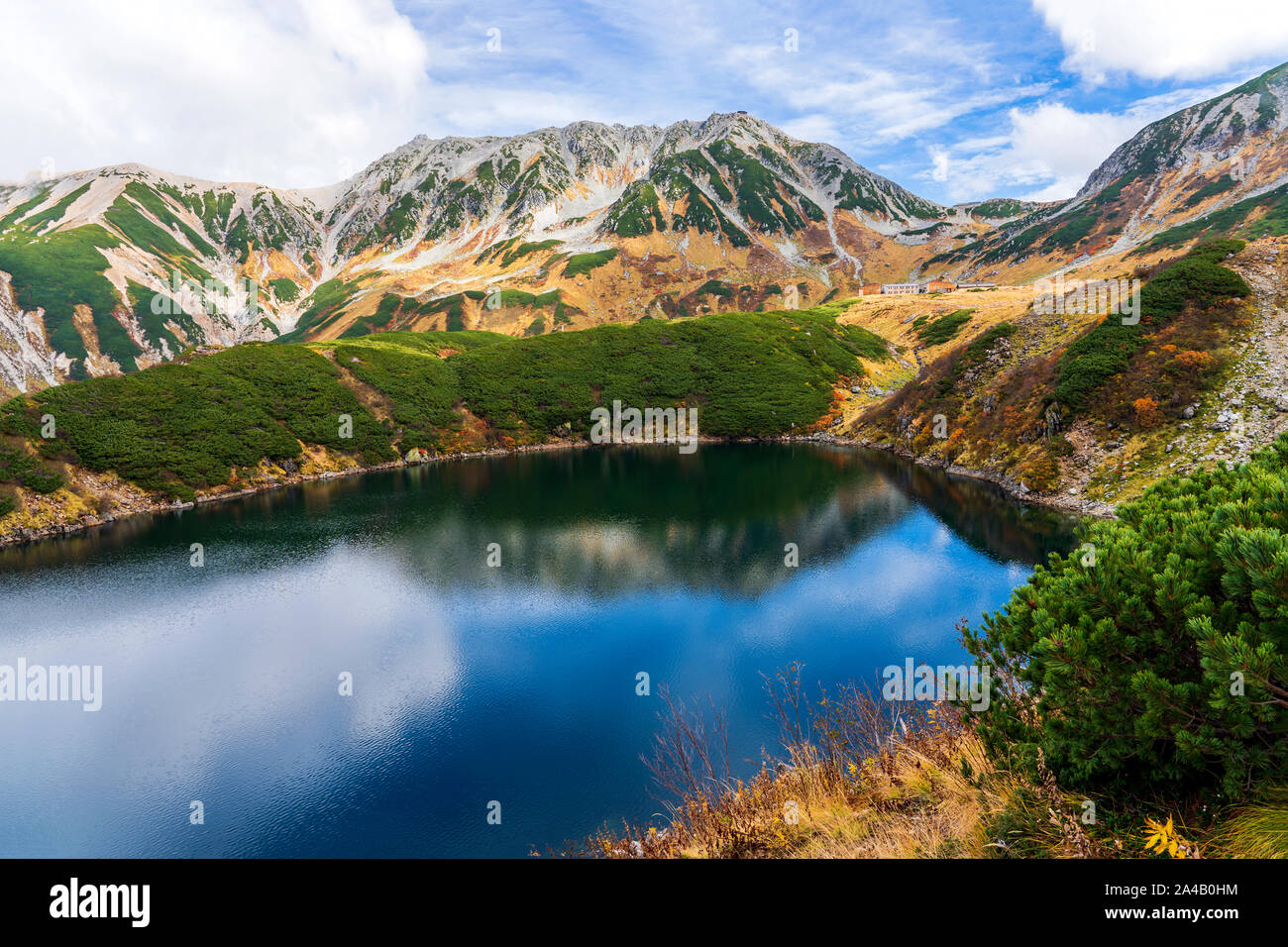 Beautiful Mountain Pond On A Sunny Day. Mikuriga Lake And Reflection Of Mountain In Water Surface in Tateyama, Kurobe, Japan. Stock Photo