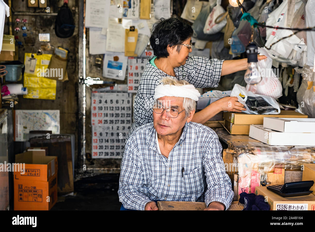 TOKYO, JAPAN - OCTOBER 6, 2018. The Asian Couple Does Family Business. Japanese Man And Woman Are Doing Home Work At Their Shop. Stock Photo