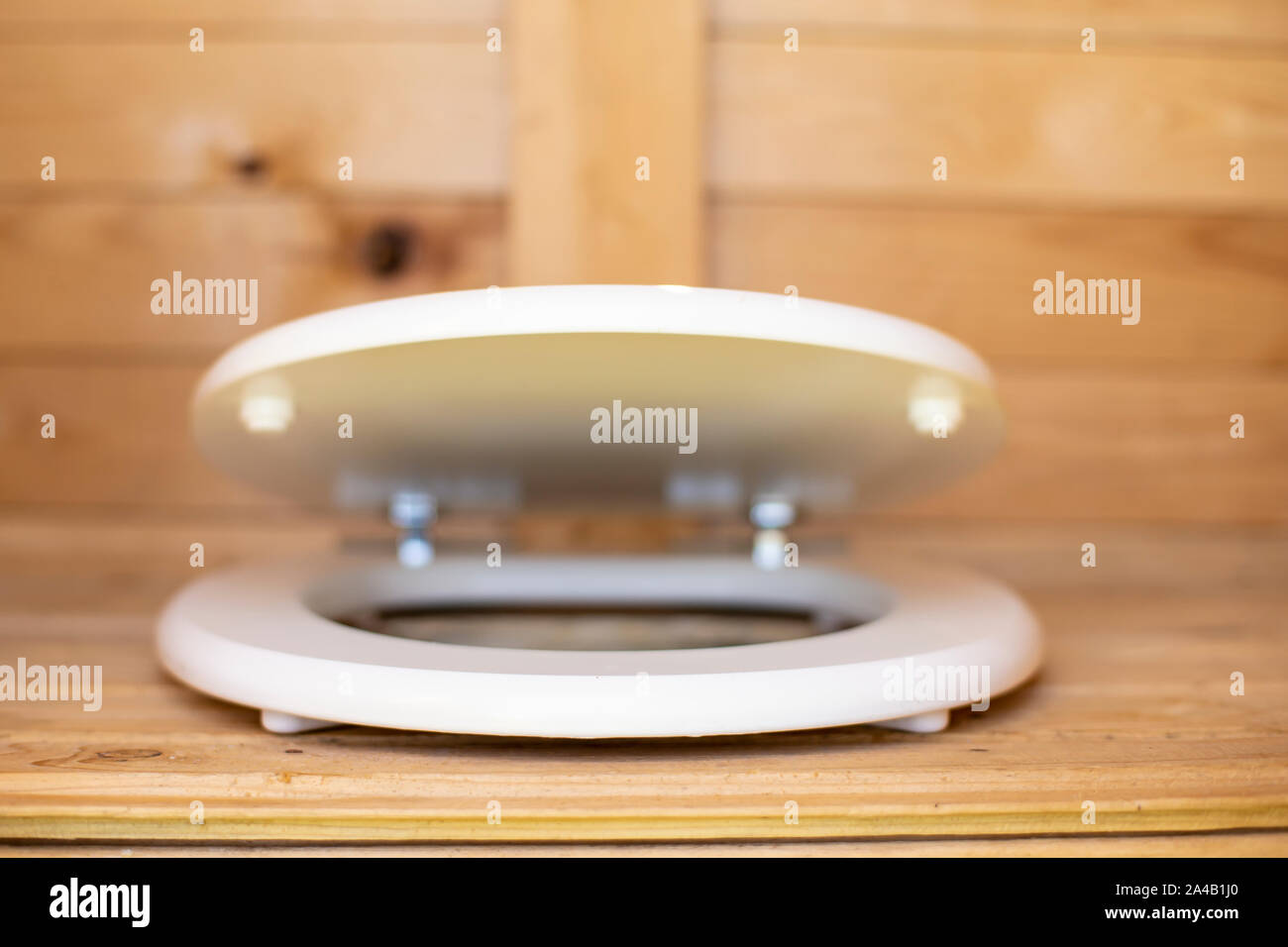 A modern, slowclosing toilet seat lid in white in a wooden, rustic