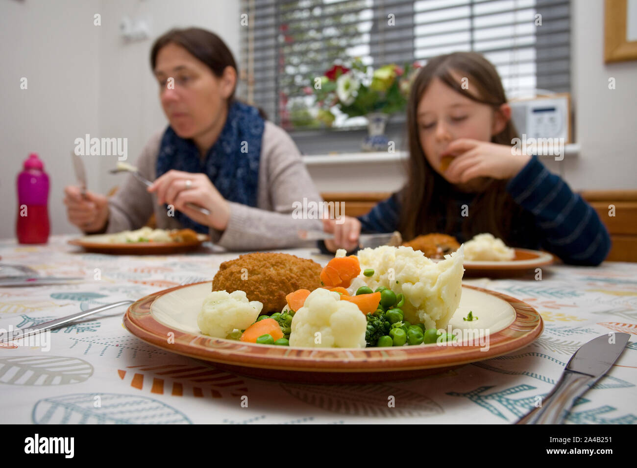 Family eating food at the kitchen table Stock Photo