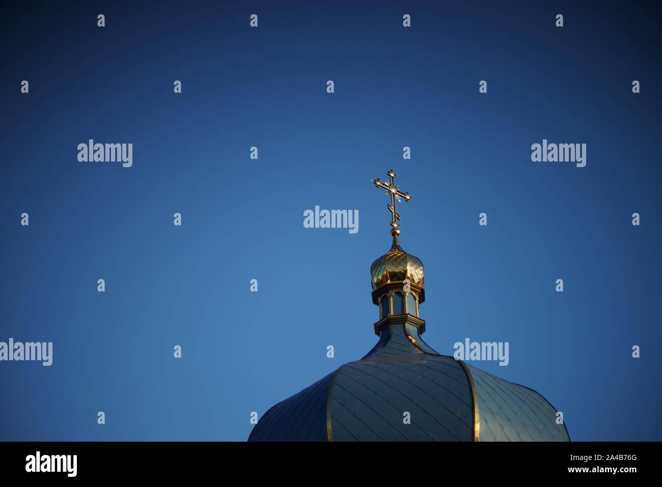 Dome of the Orthodox Church and a golden cross against a blue clear sky ...