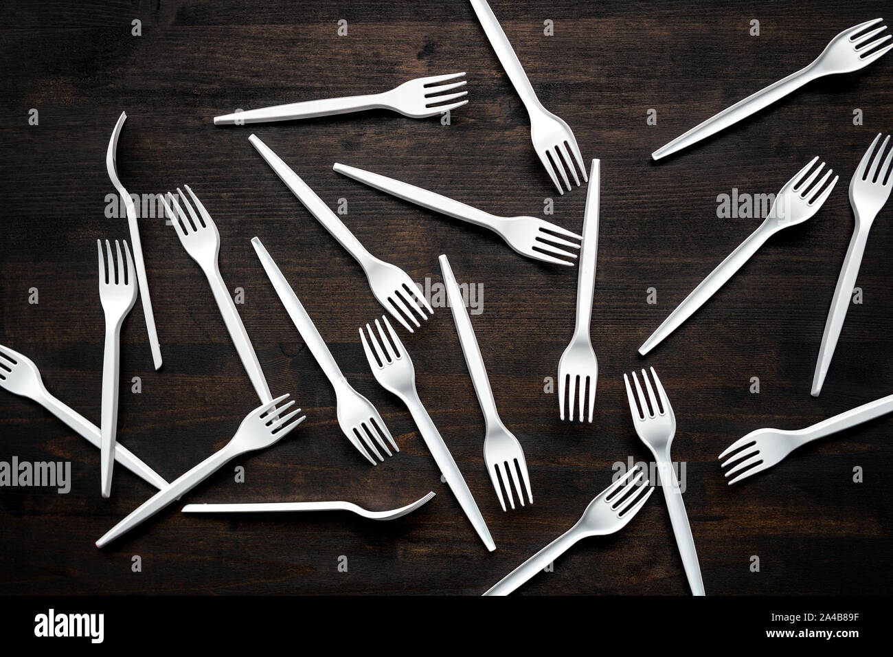 Plastic forks scattered on wooden table, top view Stock Photo