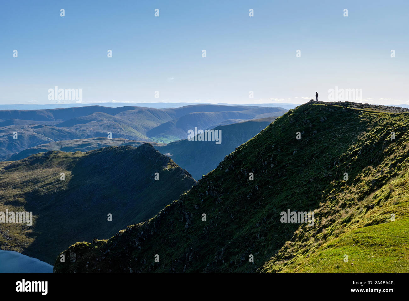 Lone hiker on the summit of Helvellyn, Lake District, Cumbria Stock Photo
