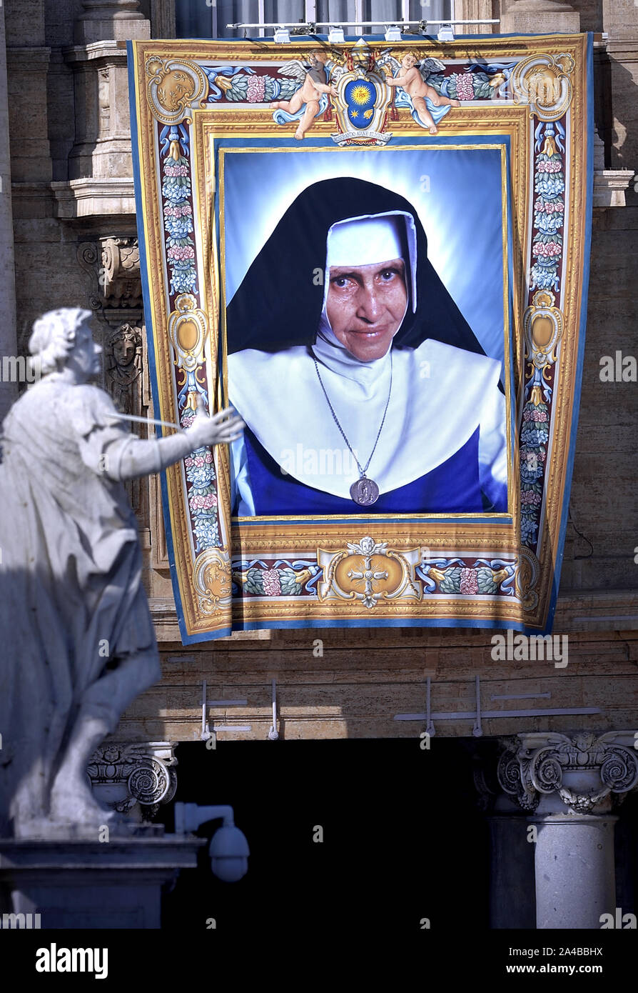 Vatican City, Vatican City. 13th Oct, 2019. Tapestry portraying Dulce Lopes Pontes hangs from the façade of St. Peter's Basilica as Pope Francis celebrates Canonization Mass for Britain John Henry Newman, Italian Giuseppina Vannini, Indian Maria Teresa Chiramel Mankidiyan, Brazilian Dulce Lopes Pontes, and Swiss Margarita Bays on Sunday, October 13, 2019, in Saint Peter's Square at the Vatican. Photo by Sefano Spaziani/UPI Credit: UPI/Alamy Live News Stock Photo