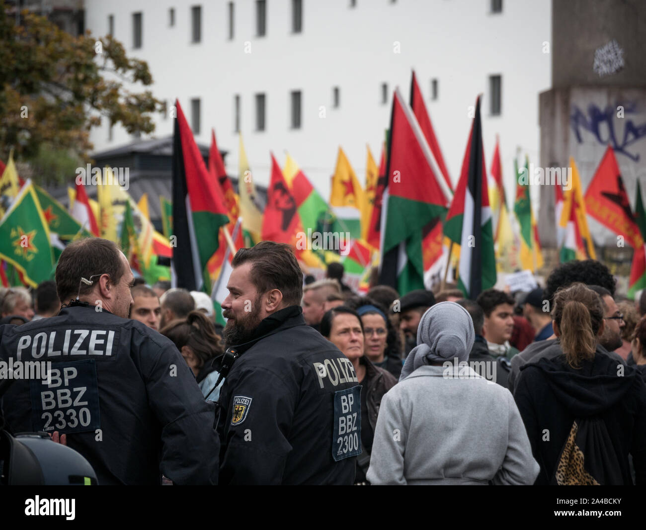Plenty policemen and police cars at protest against Turkish politics and offensive in North Syria/Kurdistan, Kurdish and YPG flags in the background Stock Photo