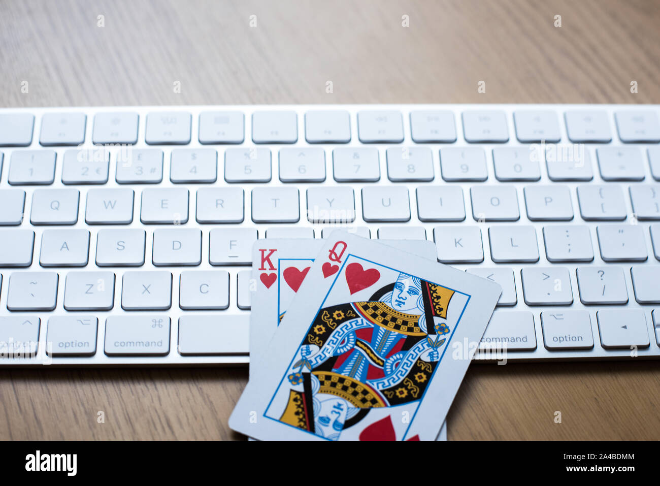 Online gambling and poker play concept with keyboard on a table with King and queen cards Stock Photo