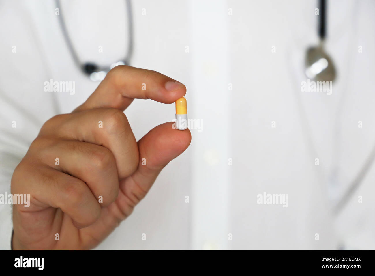 Doctor holding pill, male hand with medication in capsule close-up. Man with tablet, concept of pharmacist, drugs, diet pill, antidepressant Stock Photo