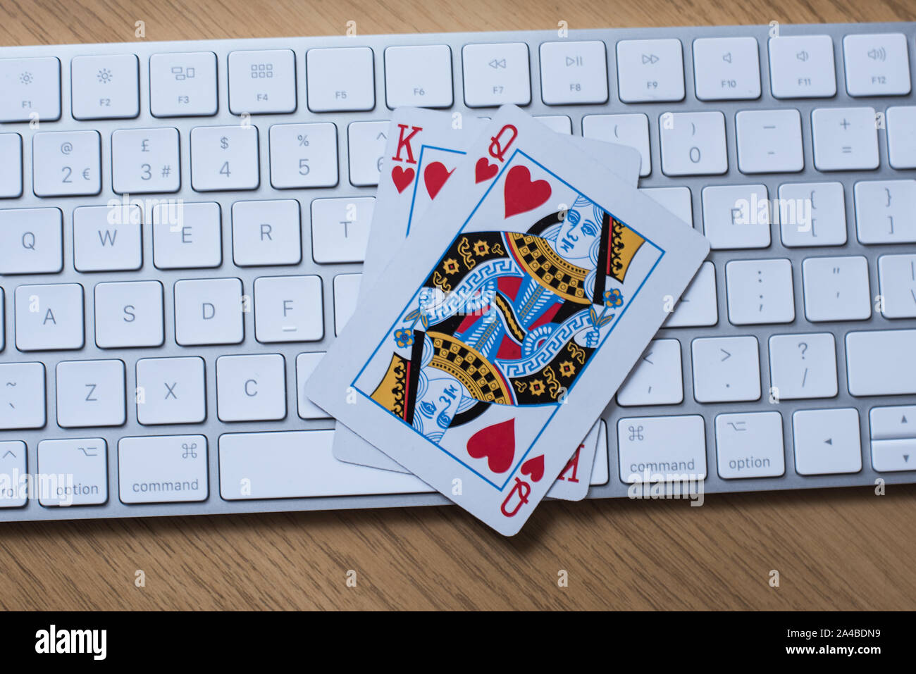 Online gambling and poker play concept with keyboard on a table with King and queen cards Stock Photo