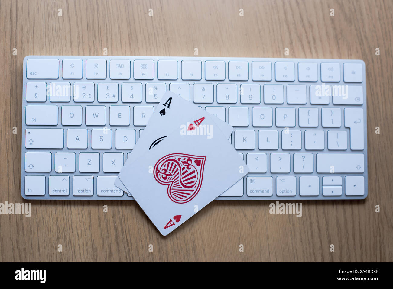 Online gambling and poker play concept with keyboard on a table showing double ace cards Stock Photo