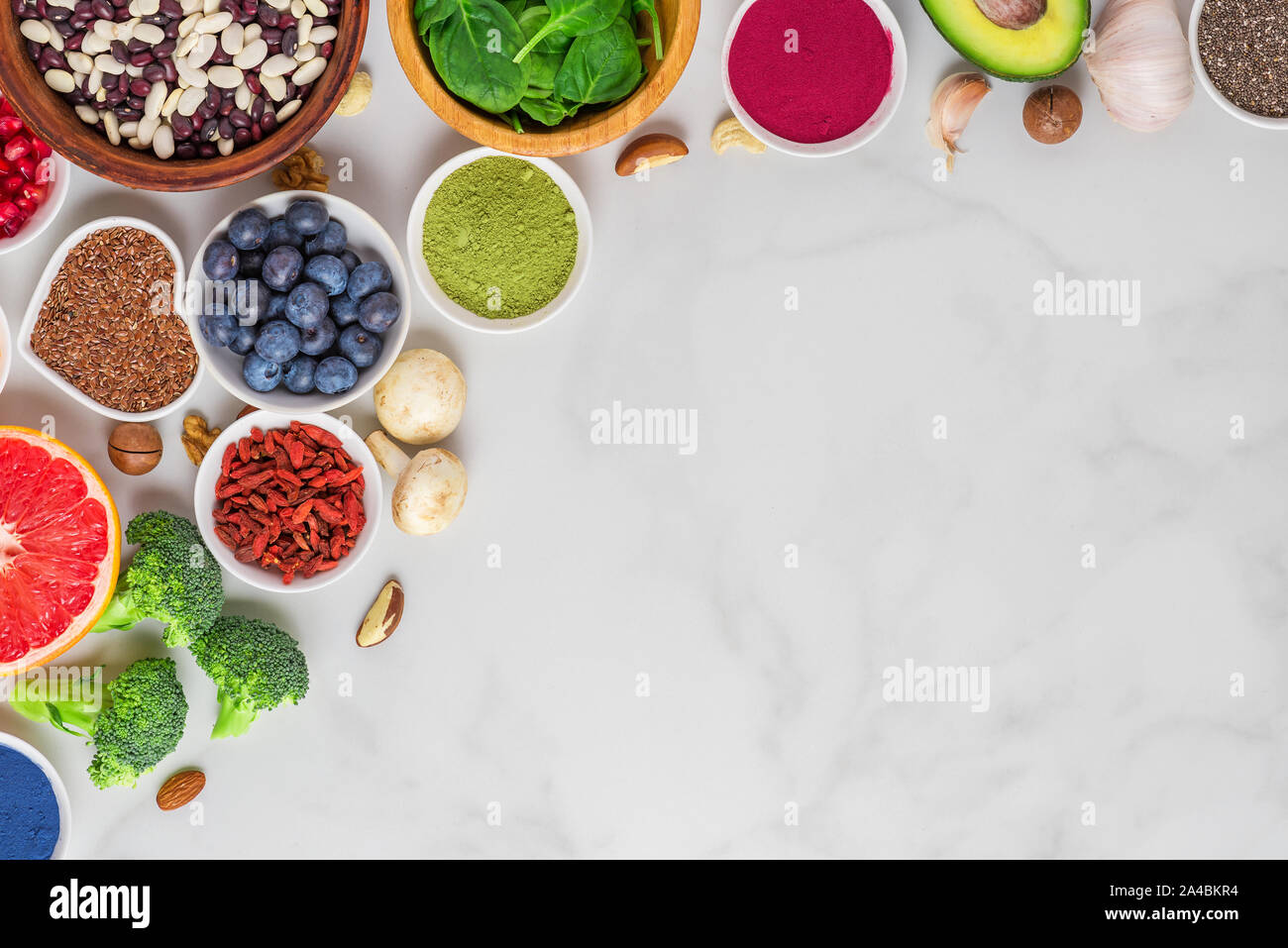 Healthy vegan or vegetarian food on whitemarble table. Vegetables, fruits, nuts and superfood. flat lay. top view with copy space Stock Photo