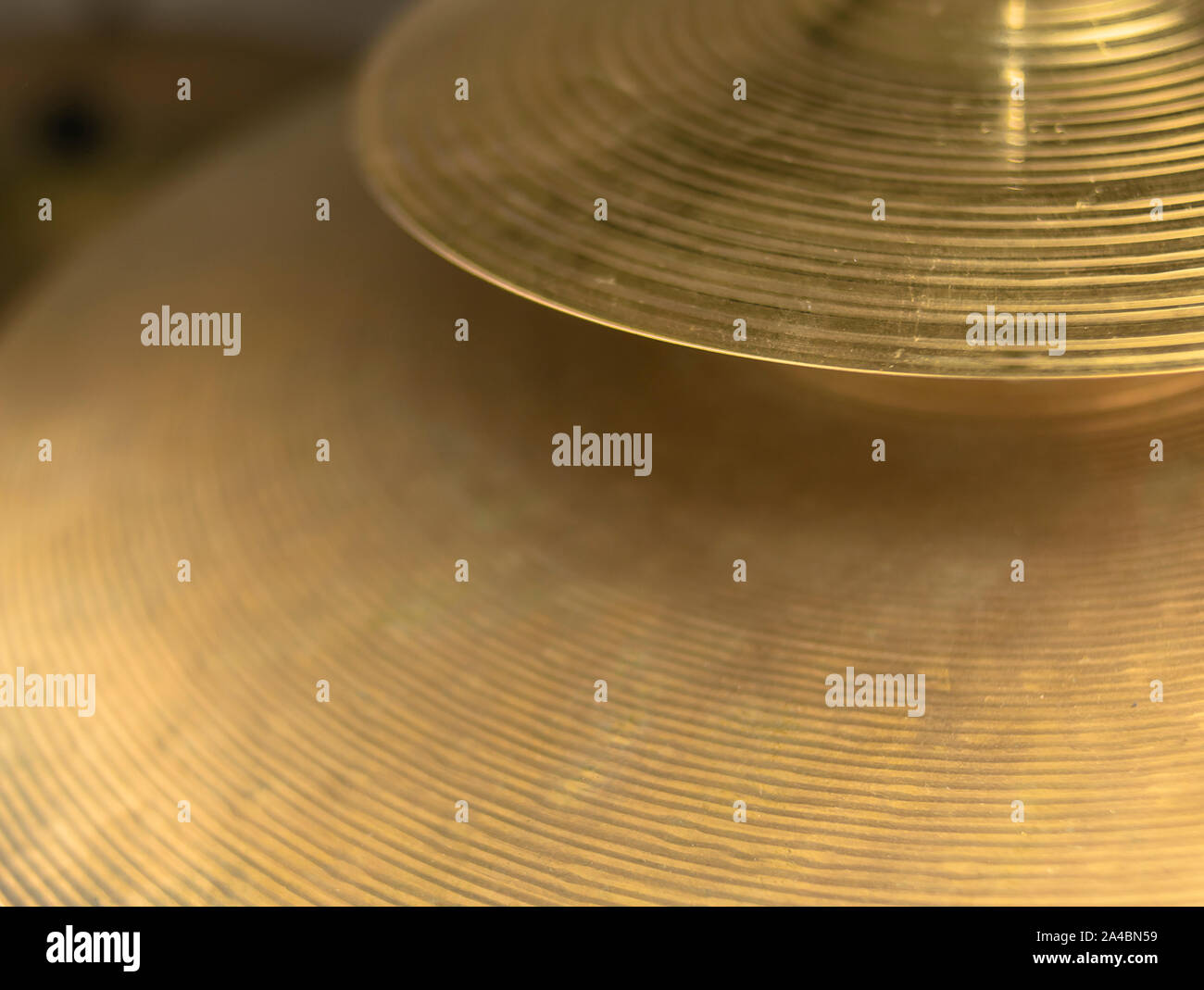 Splash and crash plates of a drum, both bright and golden, hammered and with grooves for sound diffusion Stock Photo