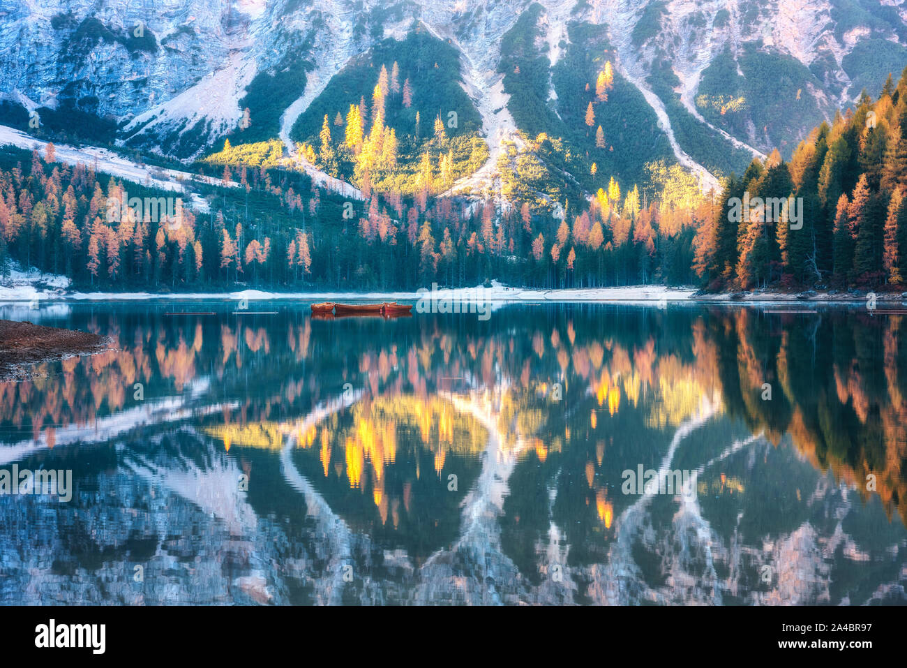Braies lake with reflection in water at sunrise in autumn Stock Photo