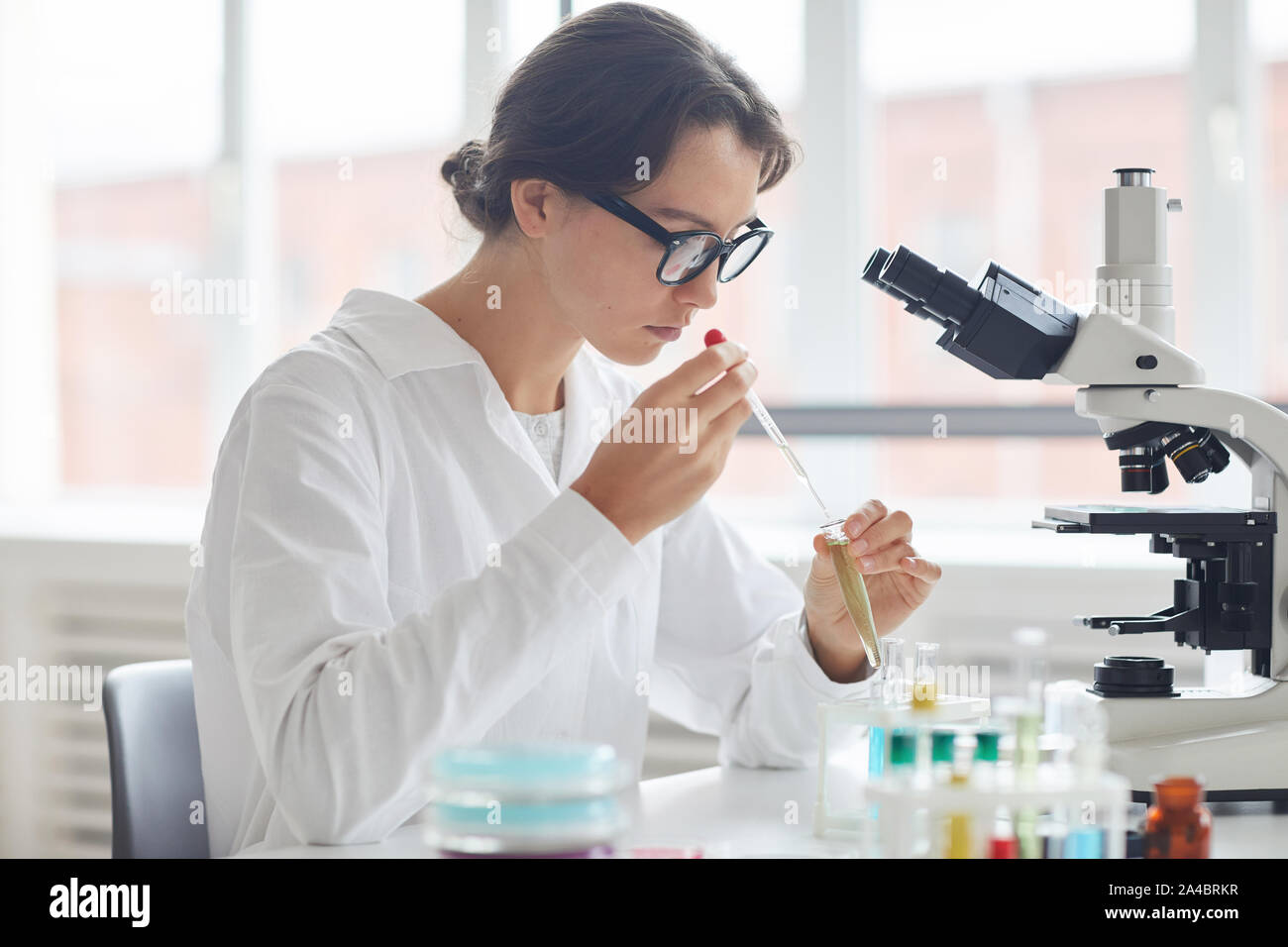 Side view portrait of beautiful young woman working in laboratory ...