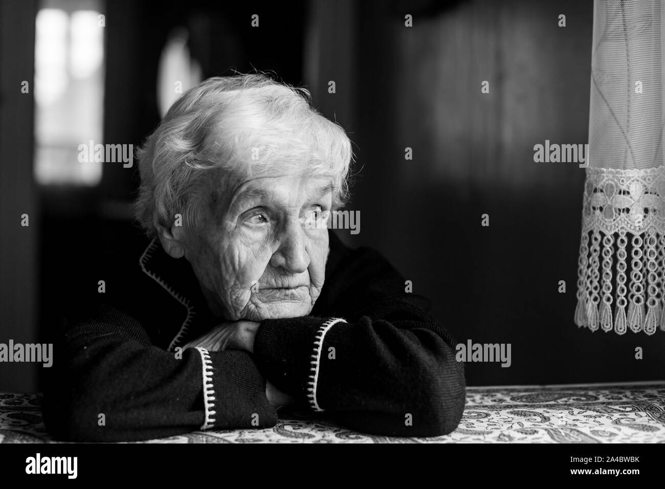 Portrait of a lonely sad old lady. Black and white photo. Stock Photo
