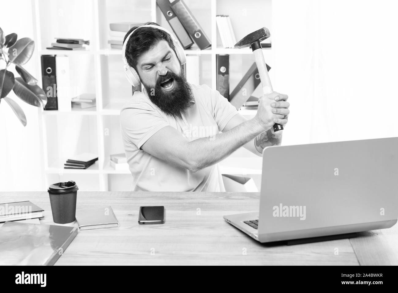 Outdated software. Computer lag. Reasons for computer lagging. How fix slow lagging system. Hate office routine. Man bearded guy headphones office swing hammer on computer. Slow internet connection. Stock Photo