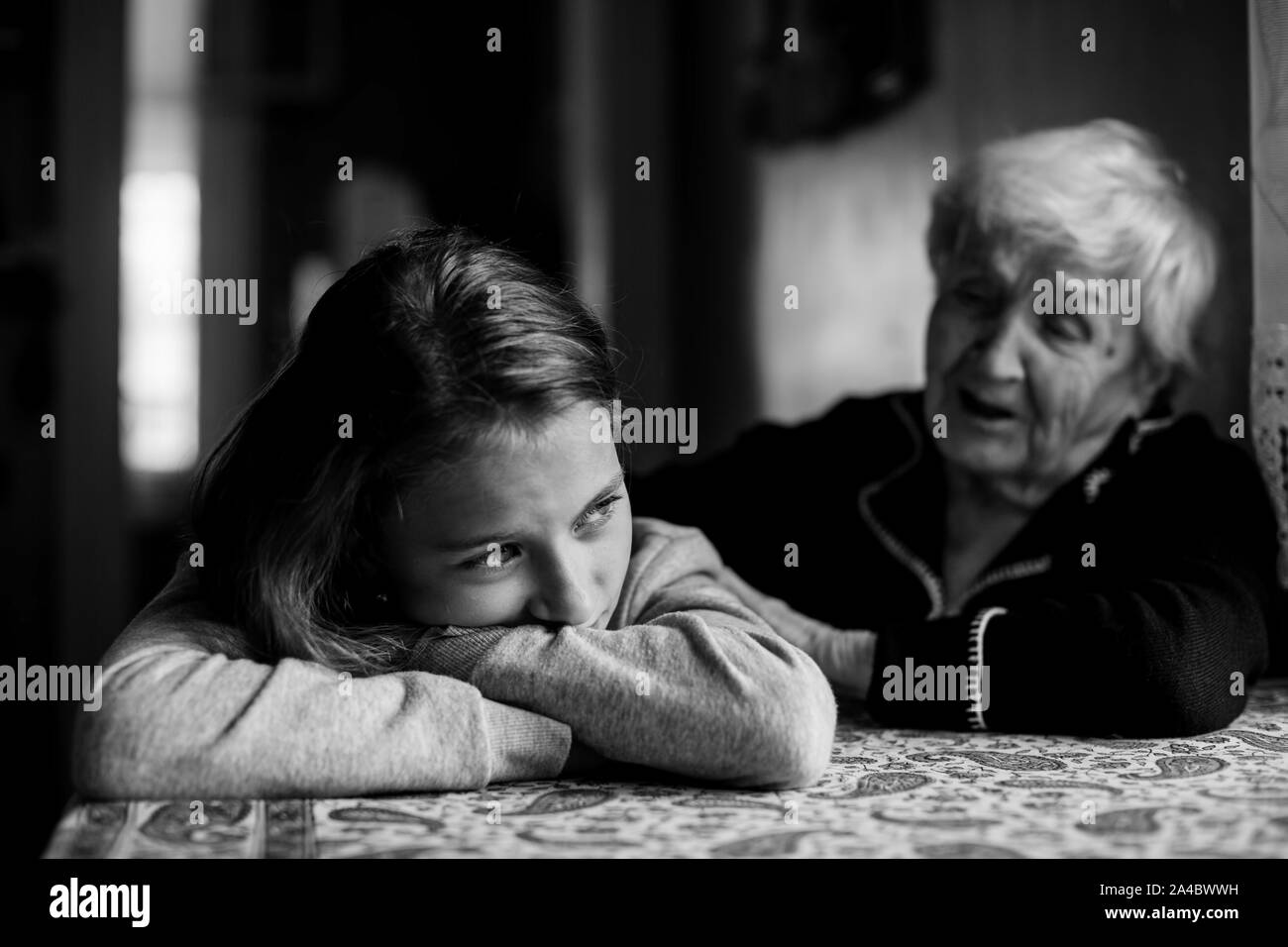 Little girl sad and grandmother soothes her. Black and white photo. Stock Photo
