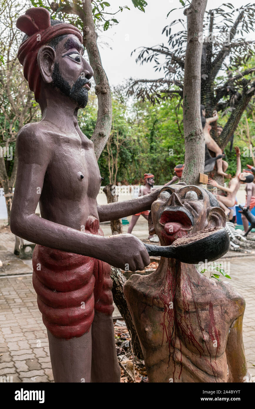 Bang Saen, Thailand - March 16, 2019: Garden of Hell in Wang Saensuk Buddhist Monastery. Scene wherein devil pours boiling lead into throat of a male Stock Photo