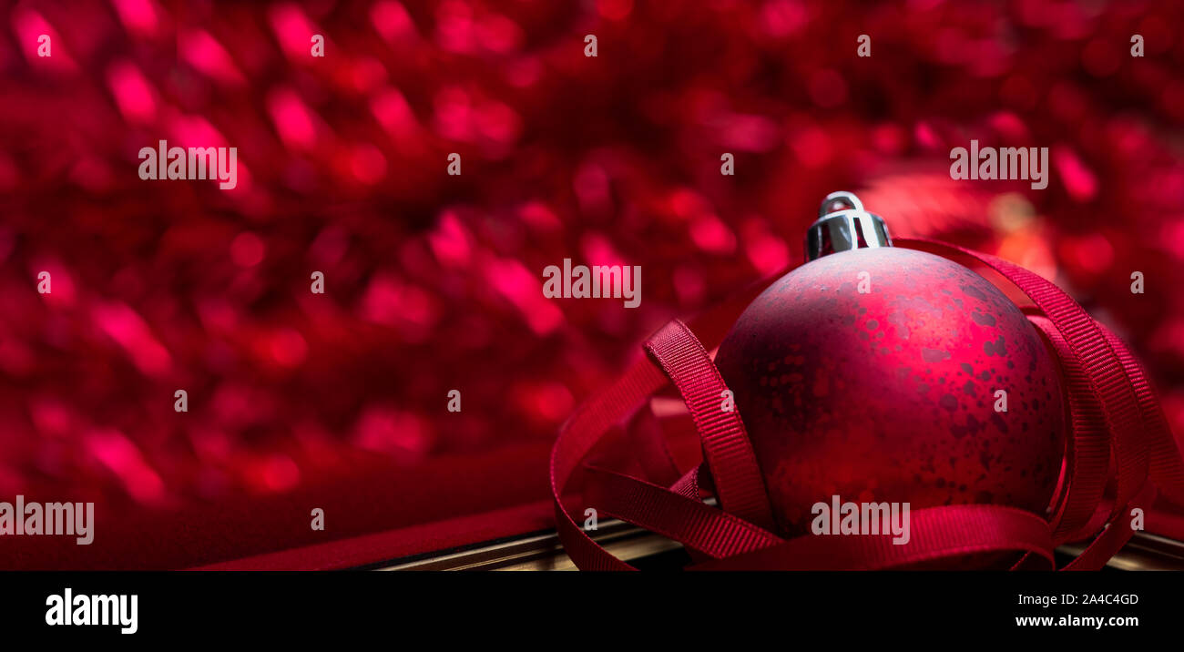 Merry christmas and happy new year red background.close up red decoration ball with blur tinsel at background.holiday celebration greeting card.banner Stock Photo