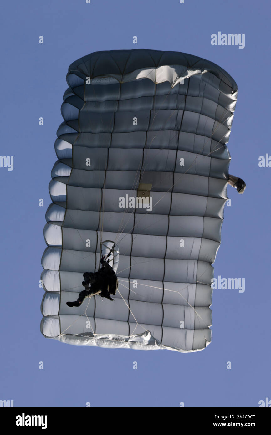 A Philippine Marine parachutes to a drop zone after jumping from a U.S. Marine MV-22 Osprey during KAMANDAG 3 at Fort Magsaysay, Luzon, Philippines, Oct. 11, 2019. KAMANDAG helps participating forces maintain a high level of readiness and enhances combined military-to-military relations, interoperability, and multinational coordination. KAMANDAG 3 is a Philippine-led, bilateral exercise with participation from Japan. KAMANDAG is an acronym for the Filipino phrase “Kaagapay Ng Mga Manirigma Ng Dagat,” which translates to “Cooperation of the Warriors of the Sea,” highlighting the partnerships be Stock Photo