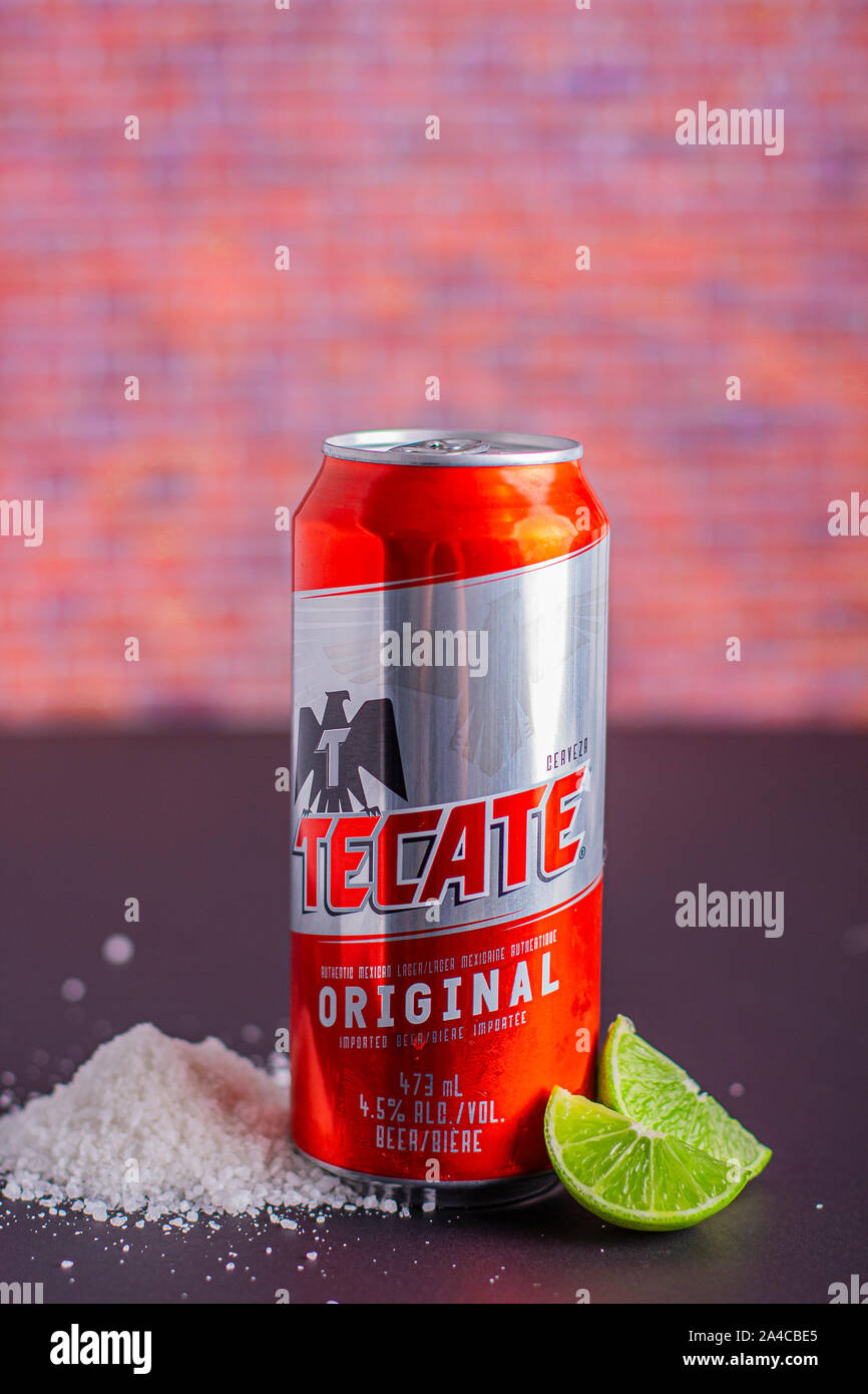 Tecate beer can with salt and limes on the side on a vertical view Stock Photo