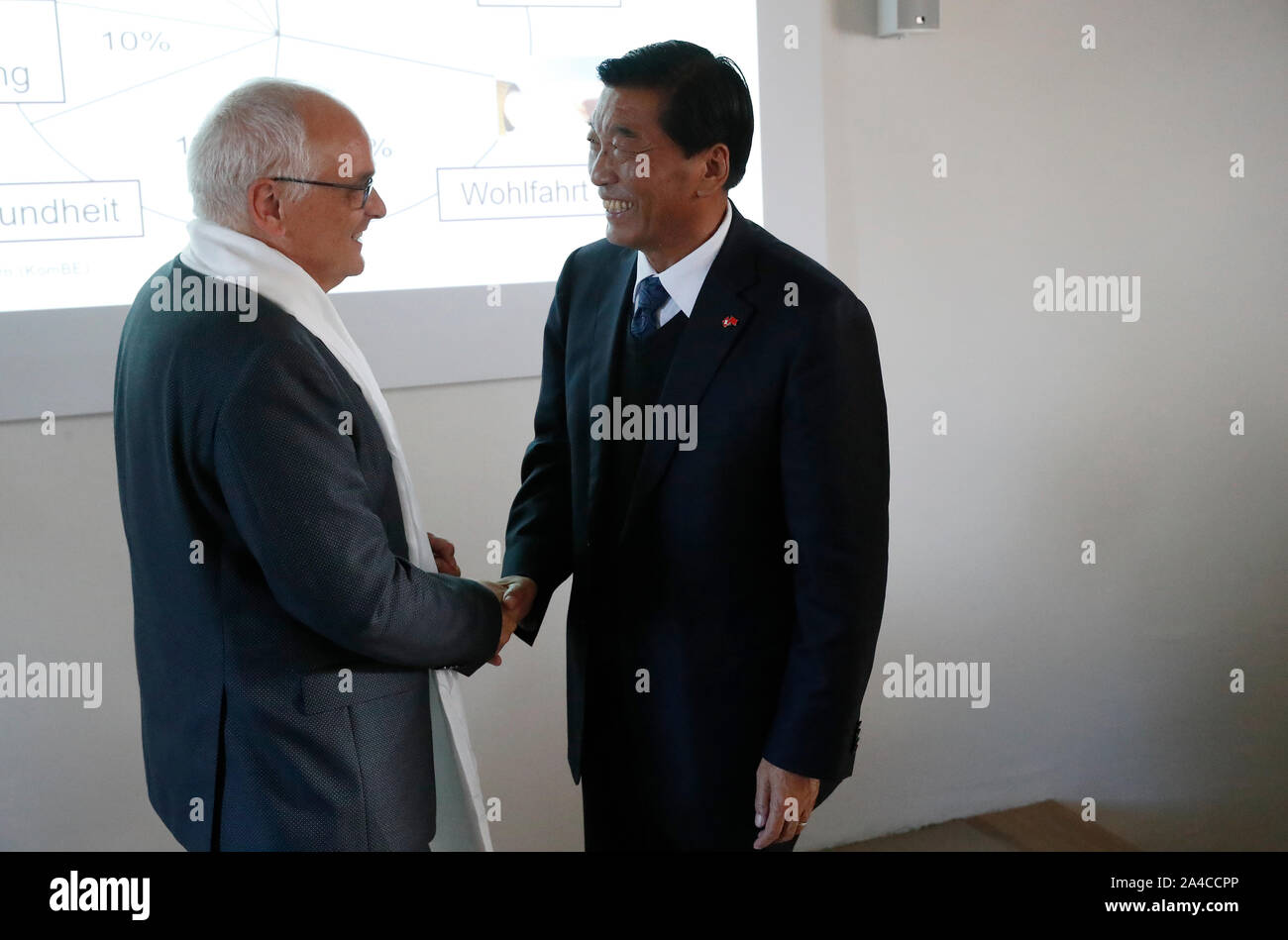 Zurich, Switzerland. 10th Oct, 2019. Nyima Cering (R), deputy director of  the Standing Committee of the Tibet Autonomous Region People's Congress,  shakes hands with Deputy Governor of Canton of Bern Pierre Alain