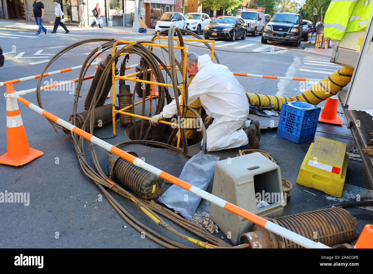 A Verizon technician at a manhole containing telephone cable and splice boxes Stock Photo