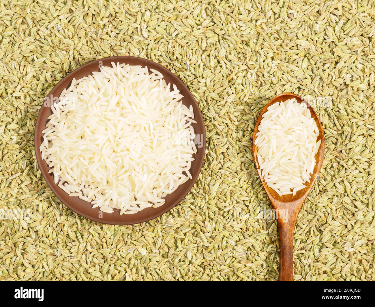 Basmati rice in clay plate and spoon. Background from Fennel. Indian cuisine ingredients Stock Photo