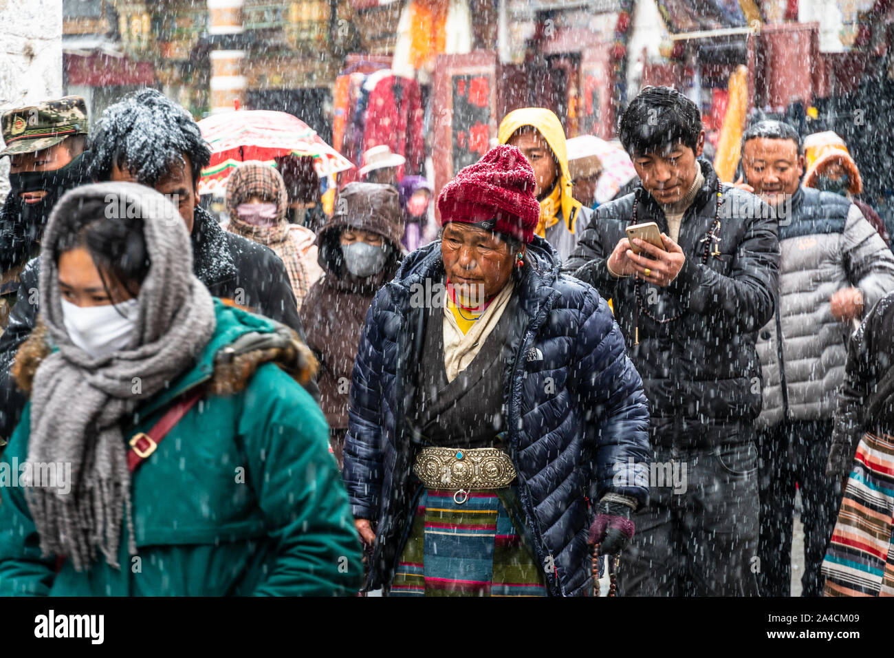 Lhasa, China - December 26 2018: Tibetan Buddhists devouts perform a kora around the  Jokhang temple  along Barkhor street in Lhasa old town in Tibet Stock Photo