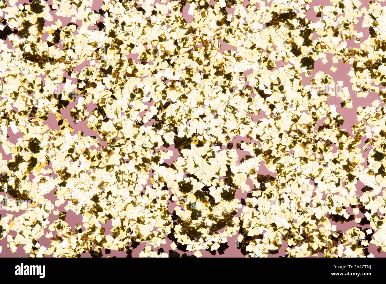 Golden confetti glitter on pink background. Festive holiday pastel ...